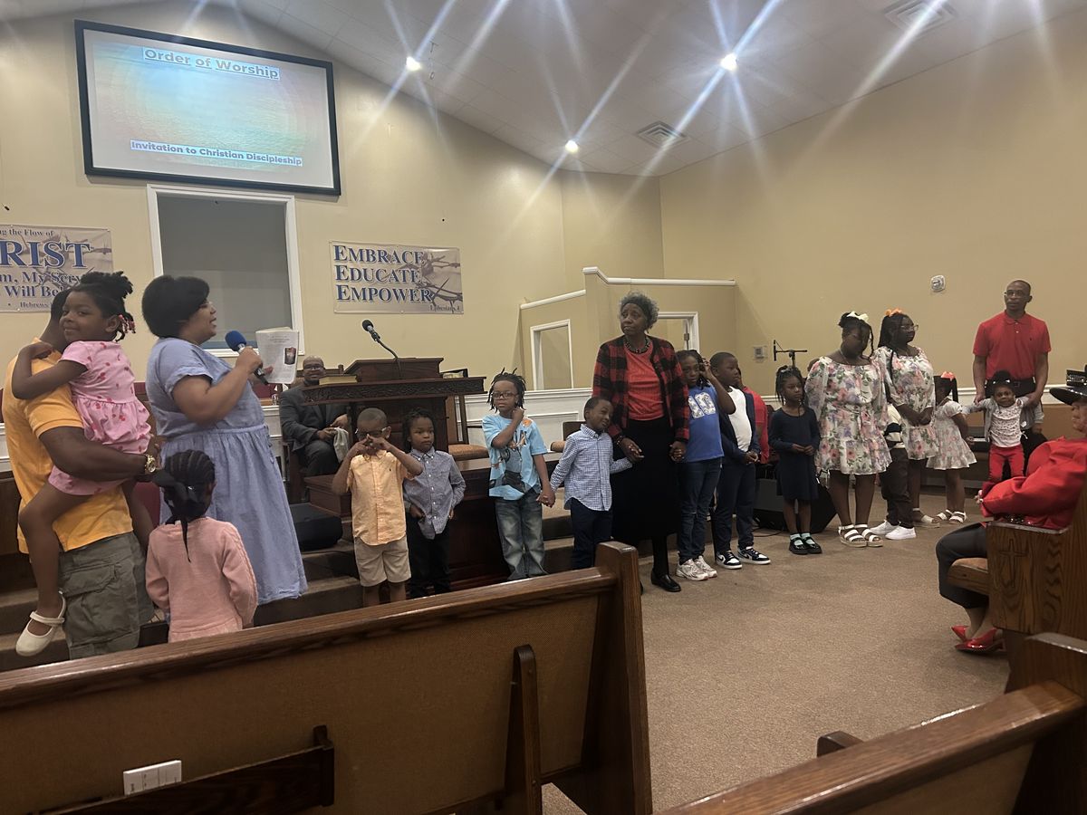 Children standing at the front of the sanctuary during worship