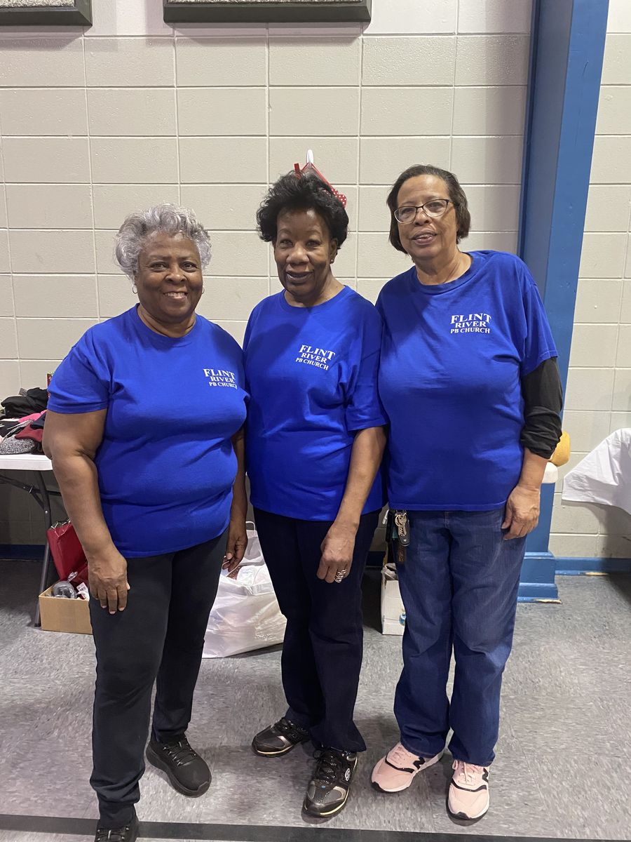 Three church mothers in matching blue Flint River shirts